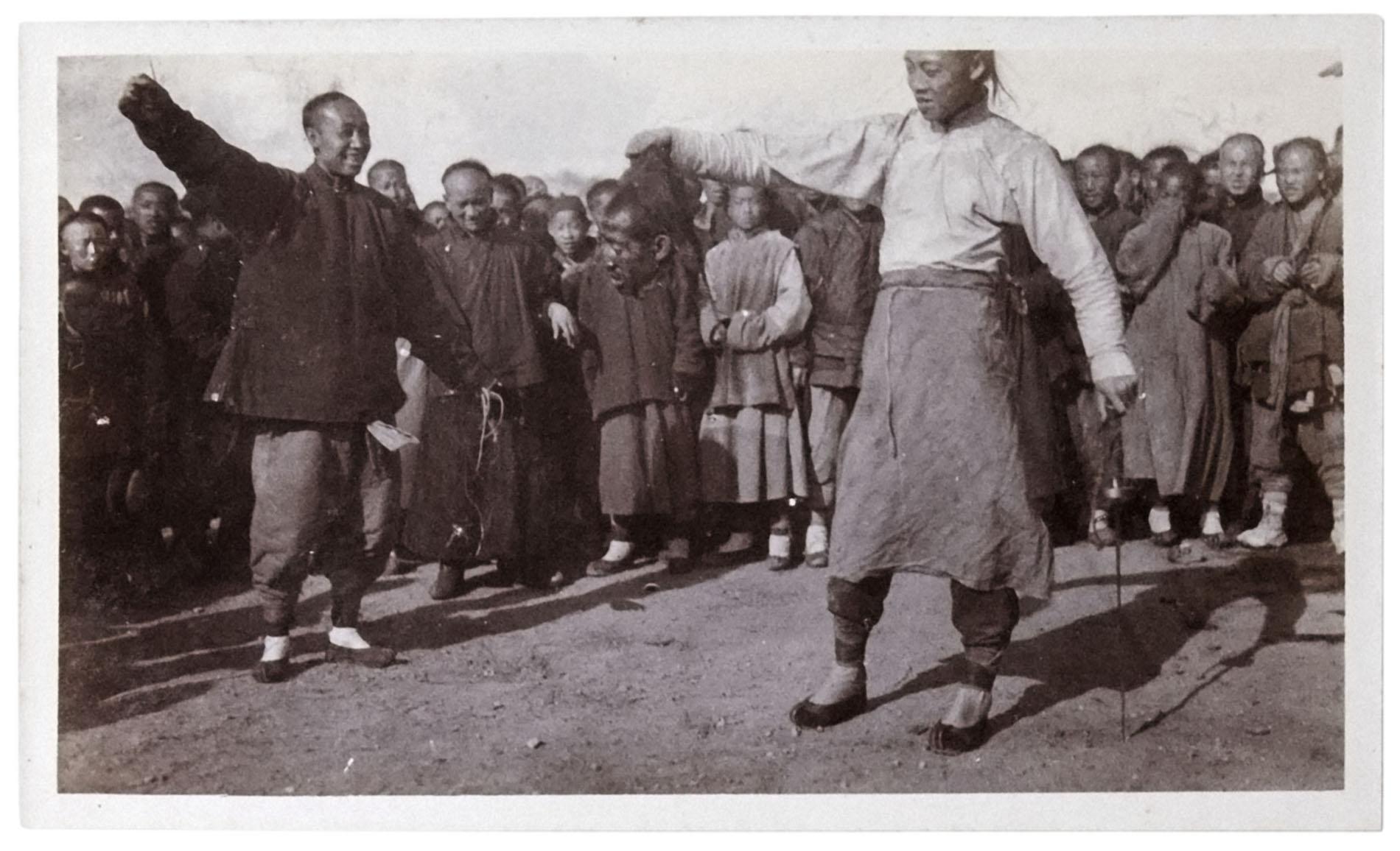 2 smiling men dance in front of a crowd