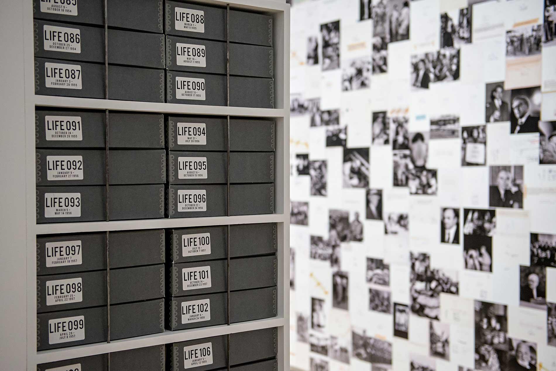 Boxes of life magazines with a wall of photographs in the background