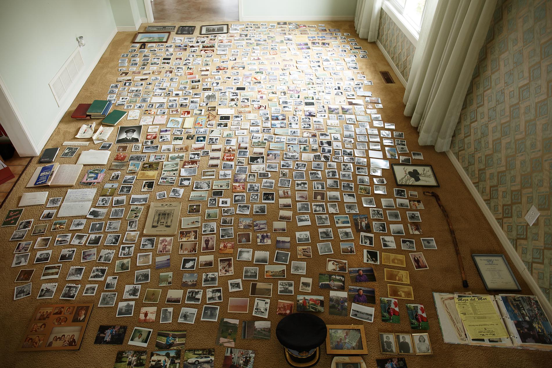 A carpeted room with photographs covering the entire floor.