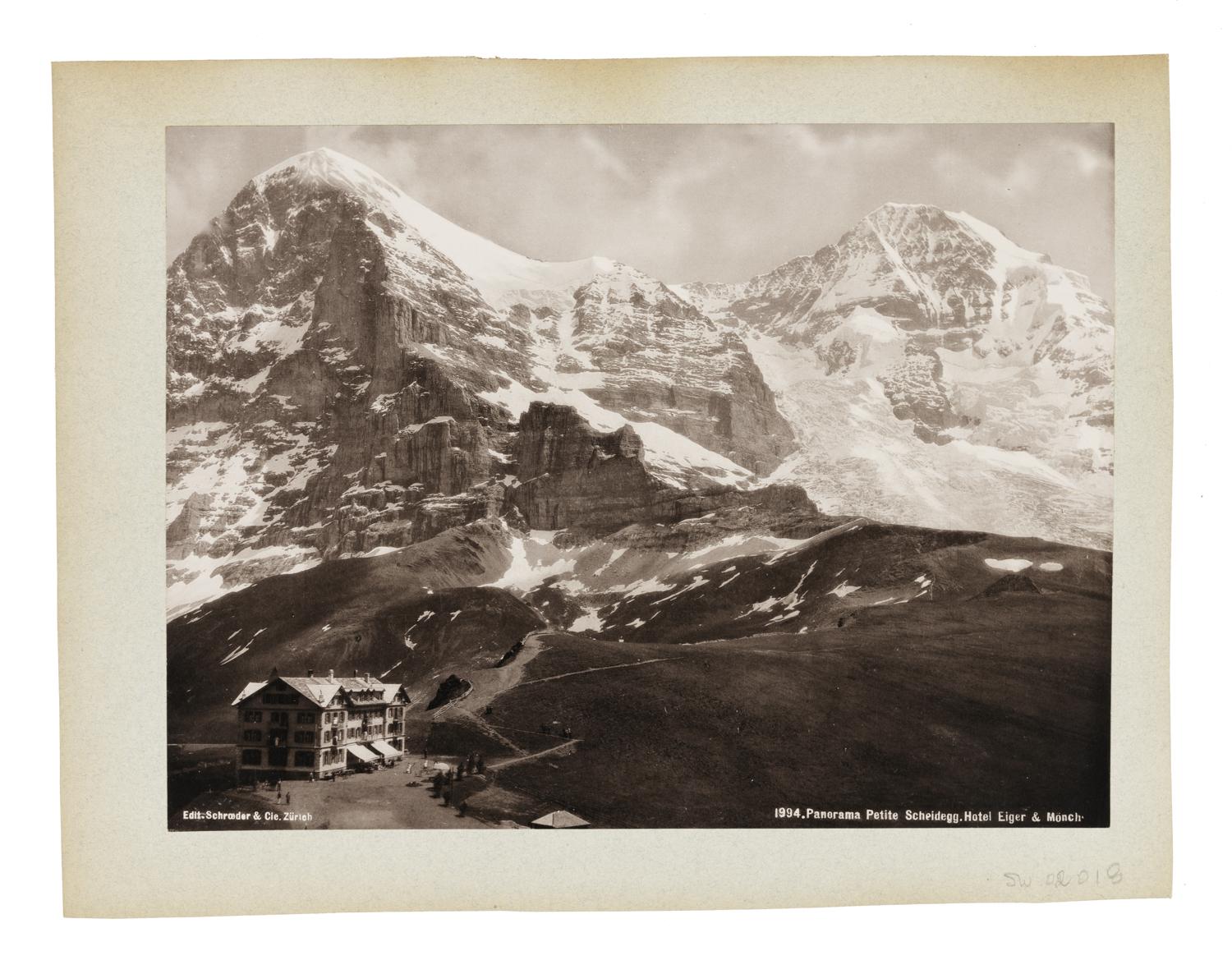 Landscape of Swiss mountain pass and a hotel in the foreground.