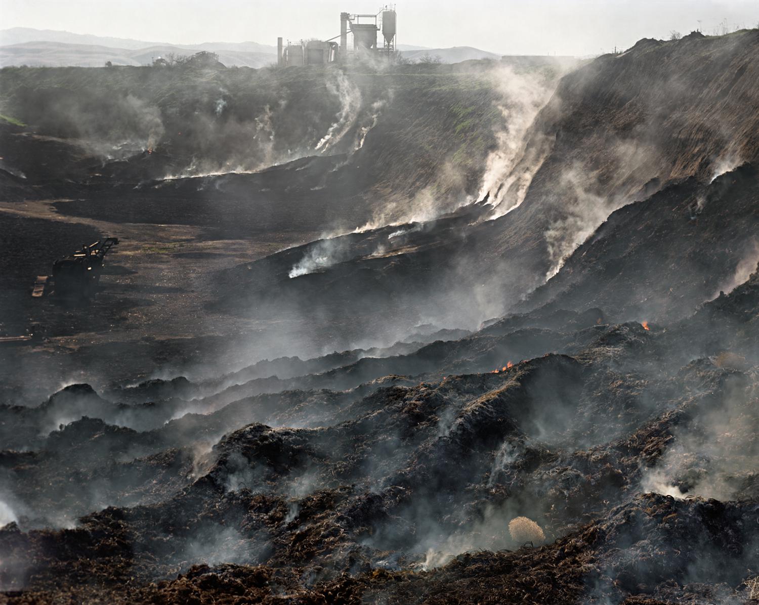 Photograph by Edward Burtynsky. A pile of burning tires.