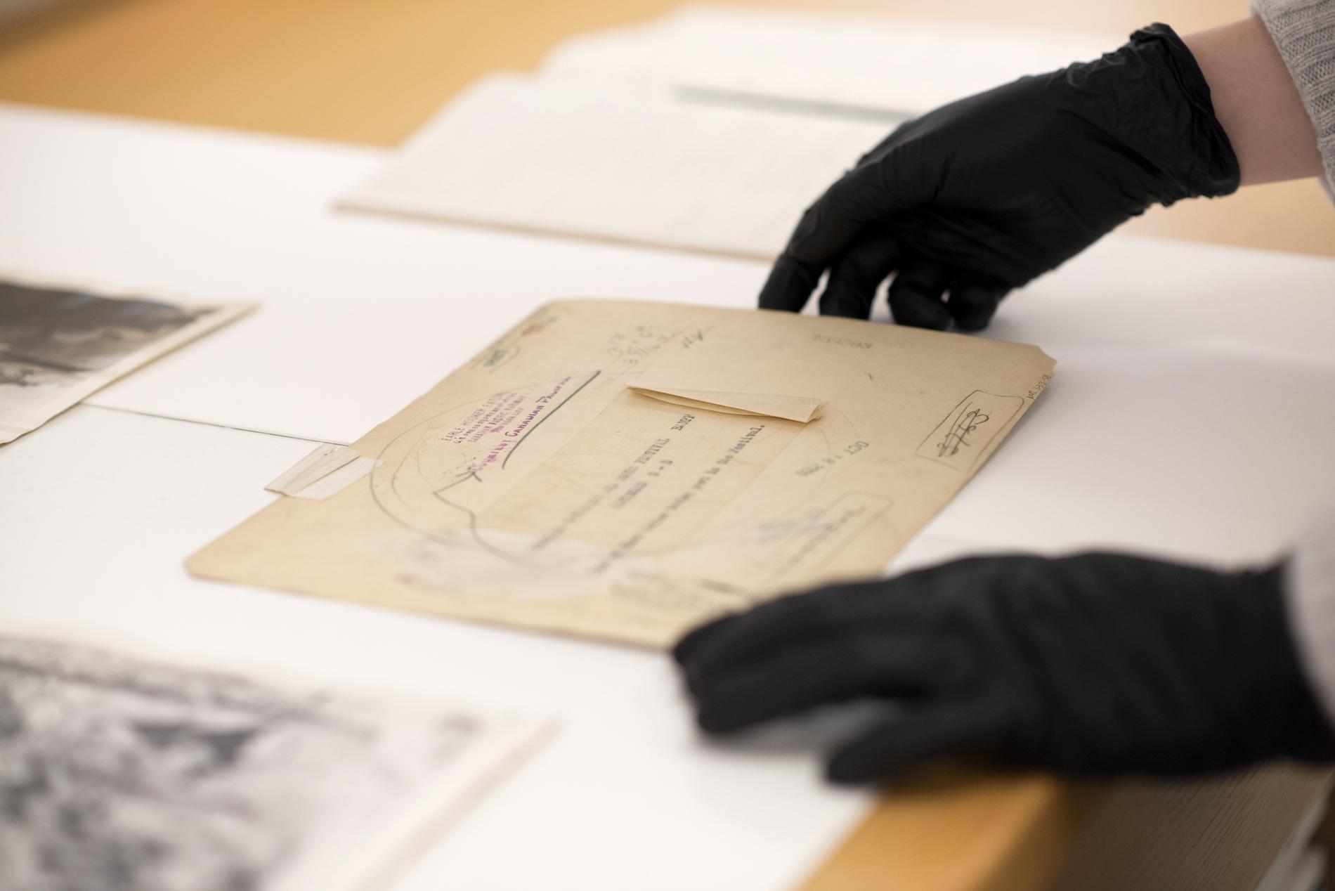 gloved hands handle photography artifacts