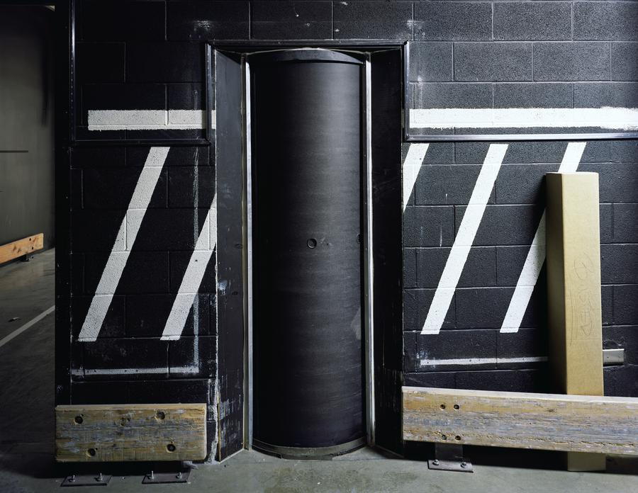 A black cement wall with diagonal white stripes