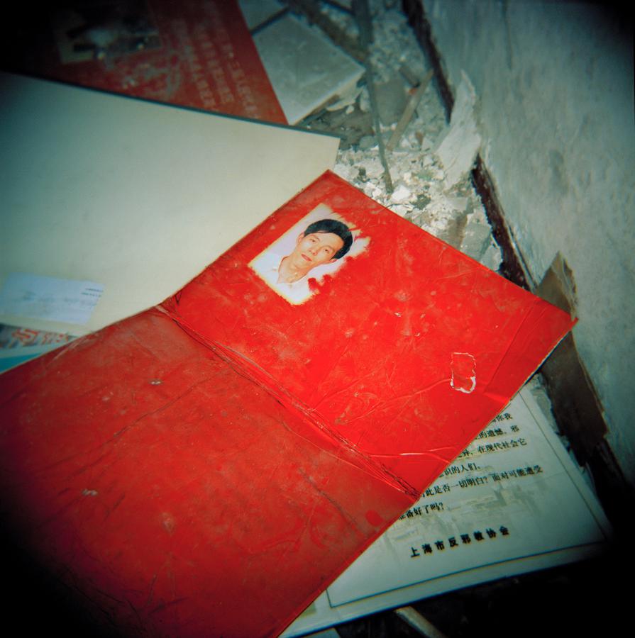 Red identification folded card with faded text and small photograph of Chinese man