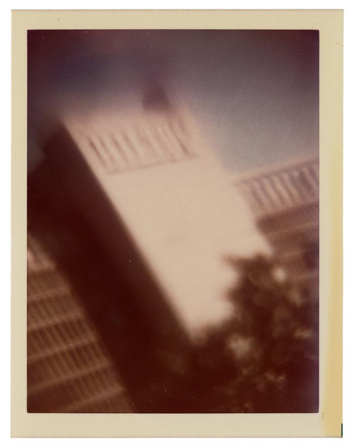 A blurred colour photograph showing a white building