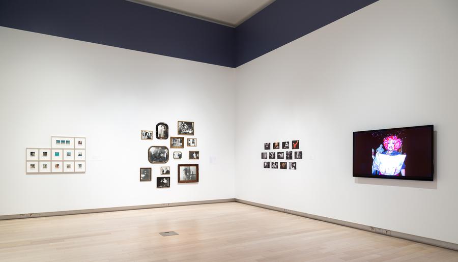 3 clusters of framed photographs and a screen in the main gallery