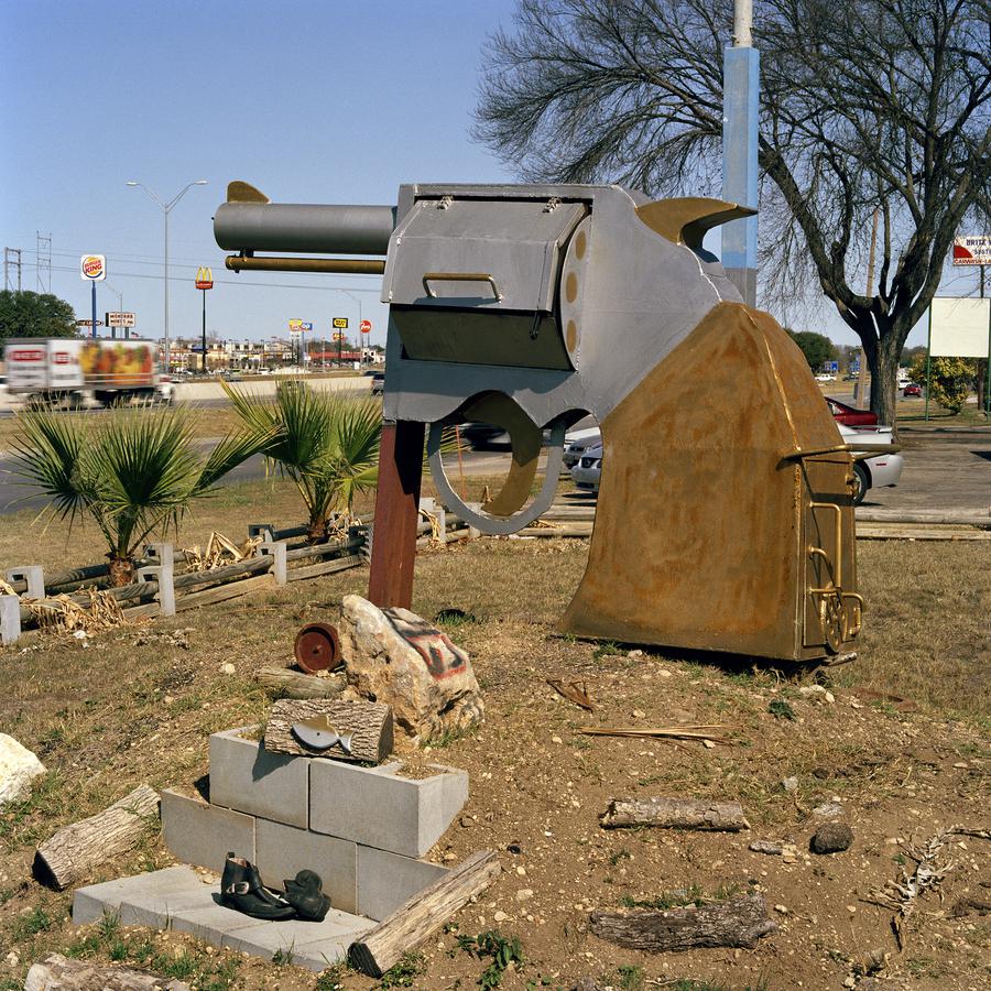 A large figurine of a pistol, outside in a commercial area