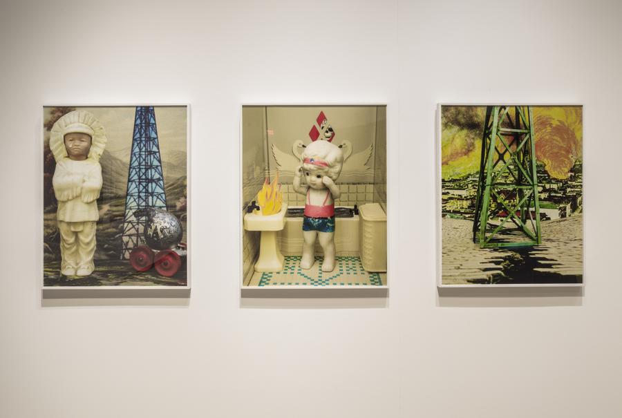 Three photographs in white frames, of plastic toys in natural disaster situations