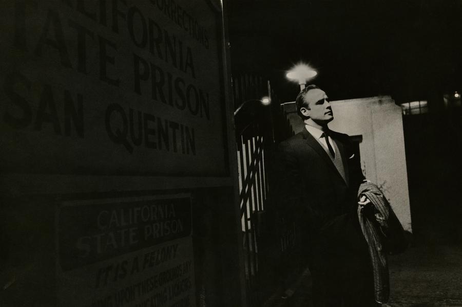 Marlon Brando wears a suit in a dark alley
