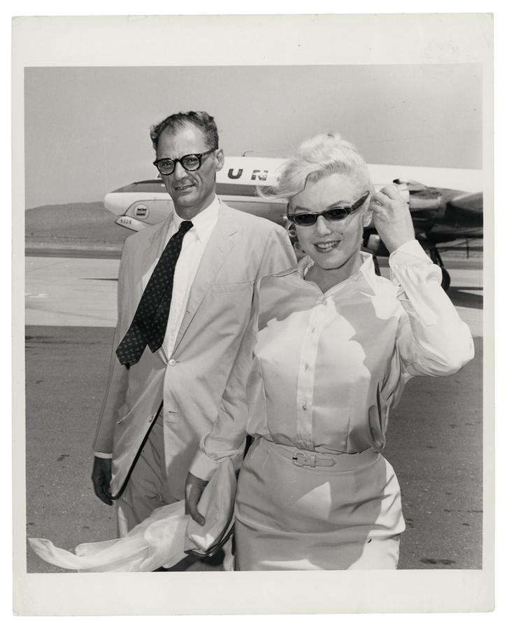 Marilyn Monroe and Arthur Miller walking away from a plane in 1960.