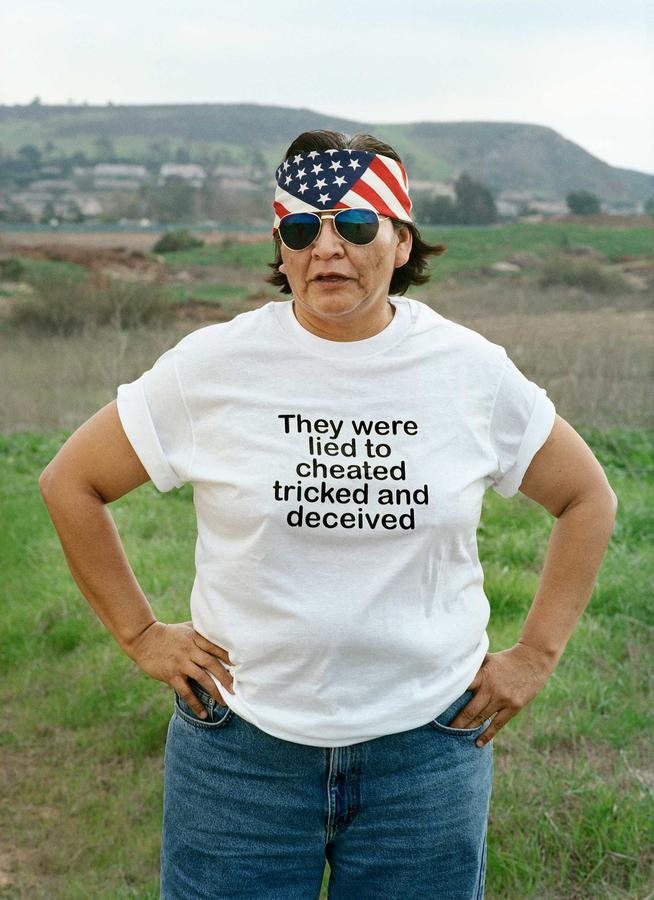 A woman wearing a shirt that says: They were lied cheated tricked and deceived