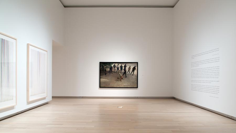 A large photograph framed in black at the end of a long gallery room