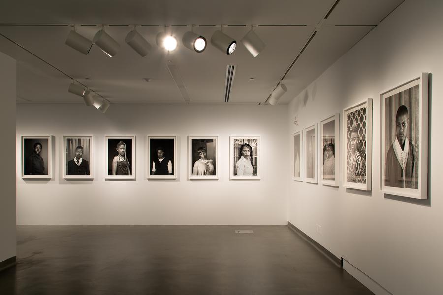 Series of black and white portraits in white frames