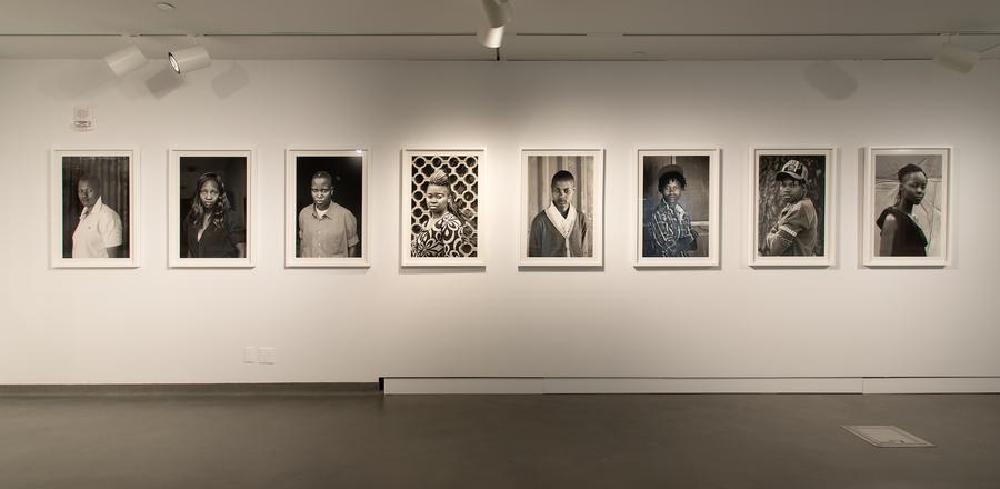 Series of black and white portraits in white frames