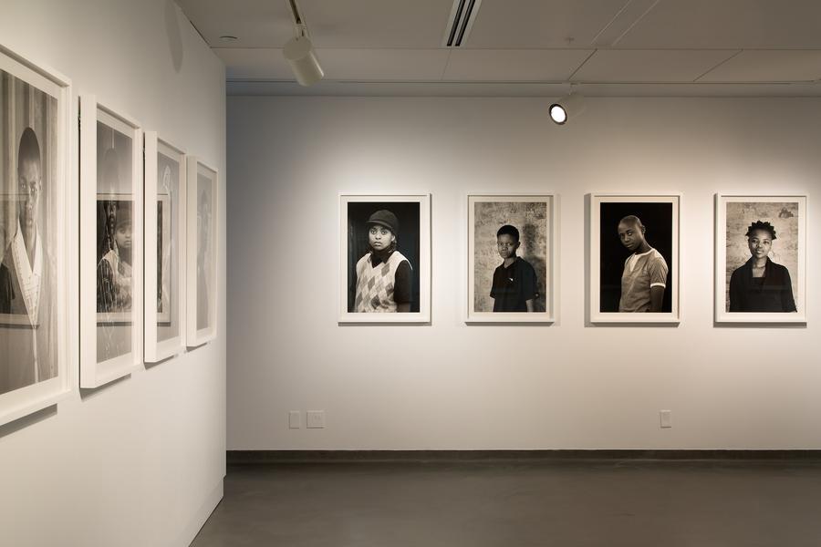 Series of black and white portraits in white frames