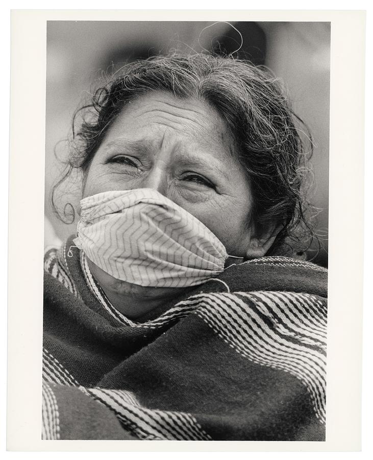 A woman wearing a face mask crying