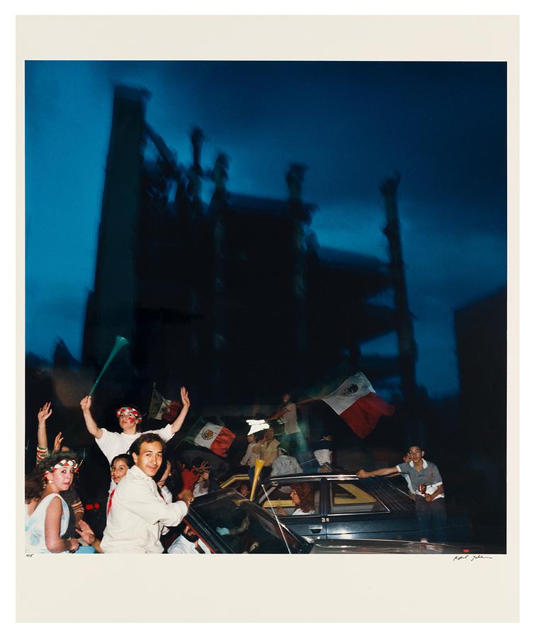 A night scene with people cheering holding flags