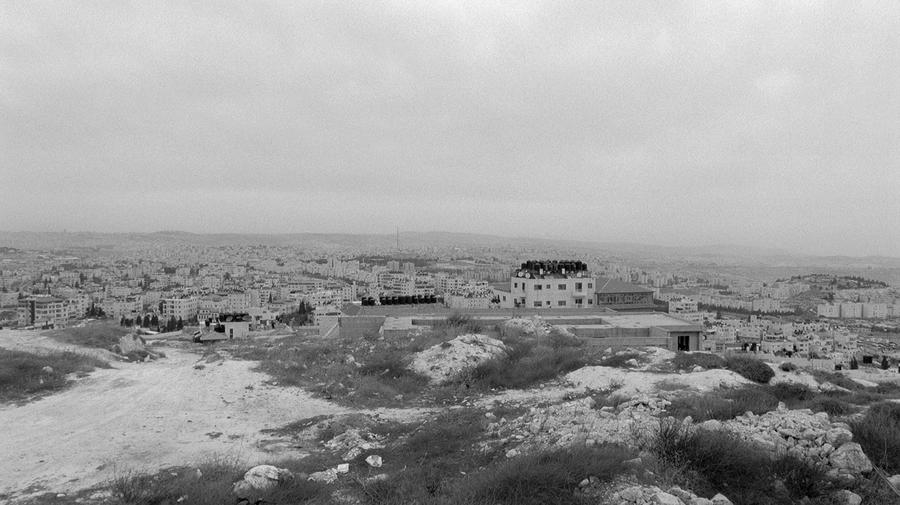 A black and white landscape overlooking a town.