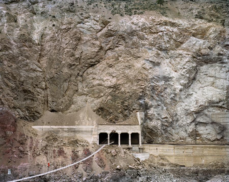 Photograph by Edward Burtynsky. A railway line cut into a mountain side.