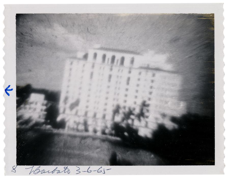 blurry off-kilter image of white building with windows, black and white