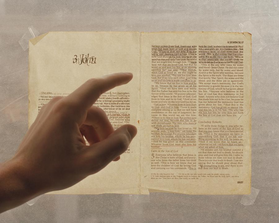 Biblical text backlit with hand pointing at it
