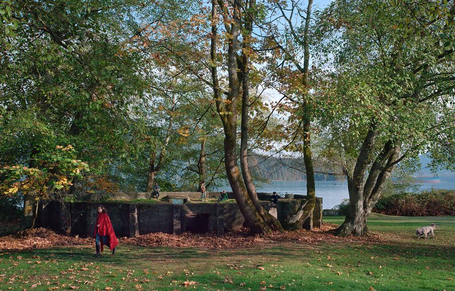 A staged scene of people in a park by the ocean.