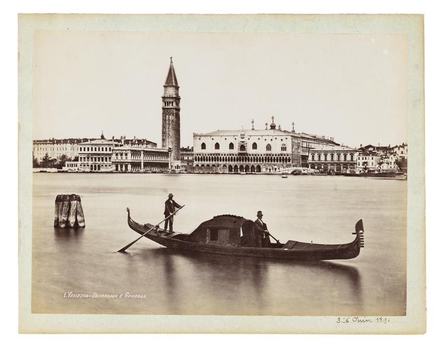 Gondoliers travelling in front of a view of Venice, Italy