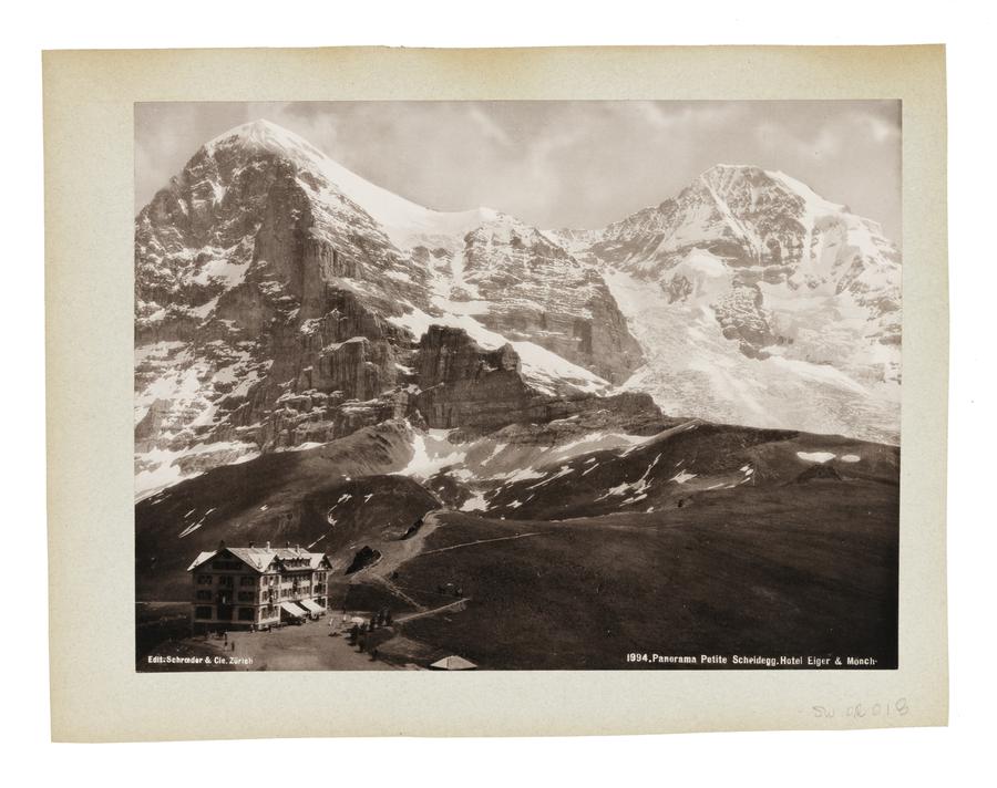 Landscape of Swiss mountain pass and a hotel in the foreground.