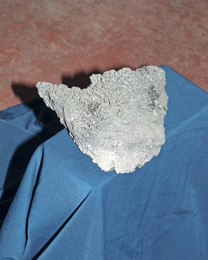 A large grey rock on a piece of blue fabric