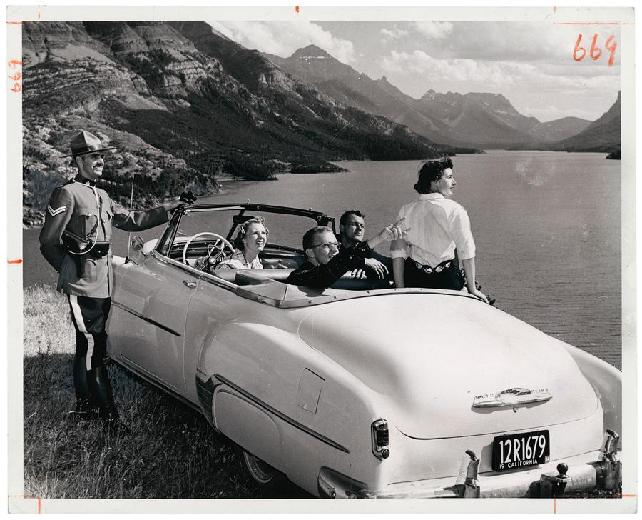 Corporal W. W. MacLeod of the Royal Canadian Mounted Police gives direction to tourists in Waterton Lakes National Park in Alberta in 1958.