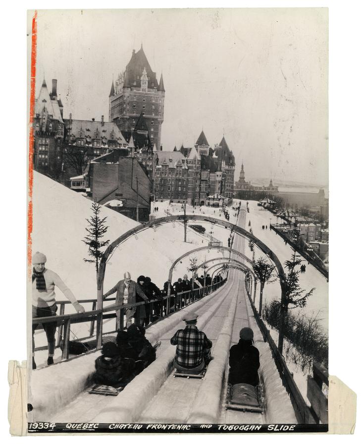 Quebec's triple-track toboggan slide, extending from the shoulder of the citadel along Dufferin Terrace past the Chateau Frontenac, Quebec City, Quebec, Canada in 1930.