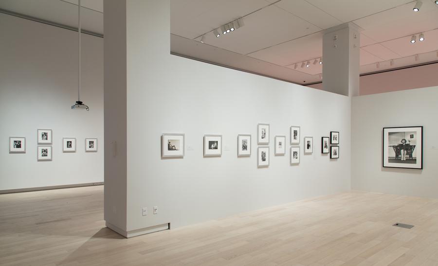 Black and white photographs in grey frames on a white wall