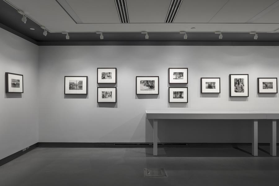 Black and white photographs in black frames in a linear pattern on a white wall