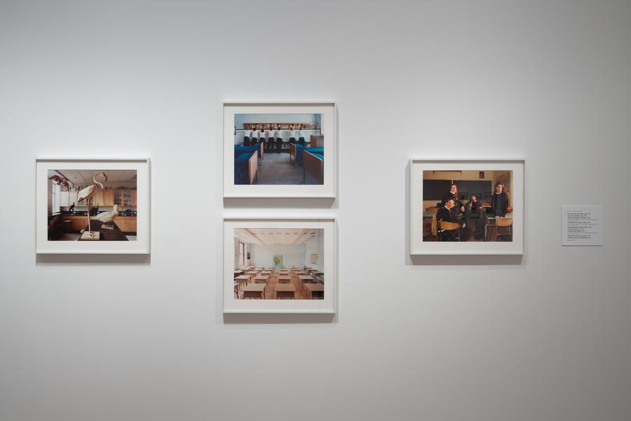 installation shot of four frames showing artist's school series depicting students in classroom environments