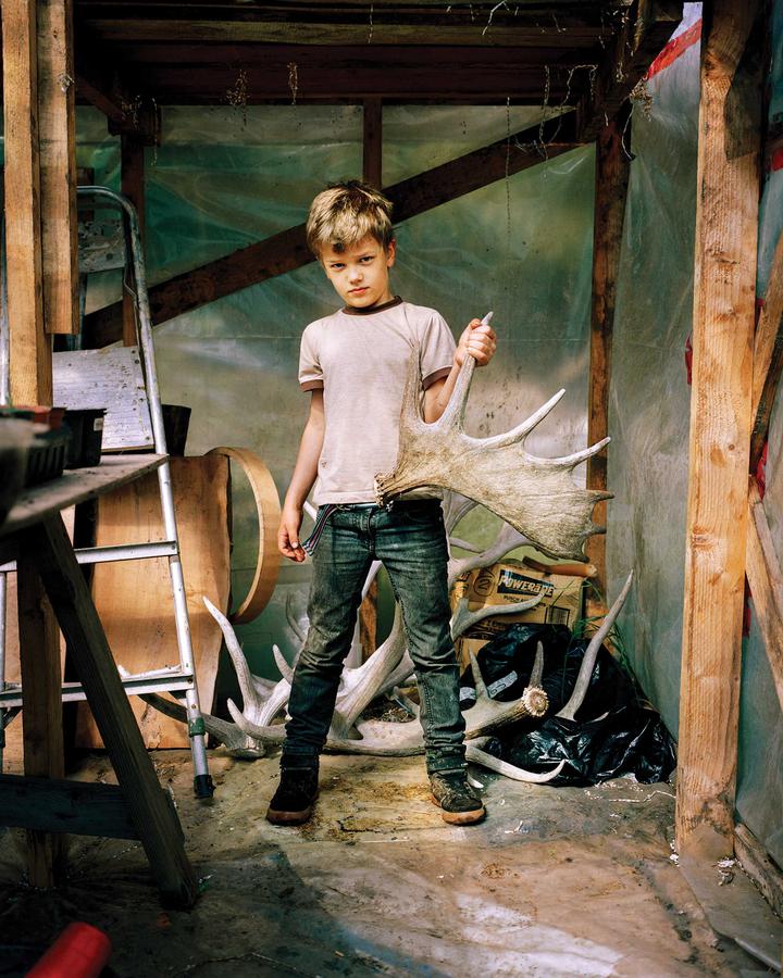 A boy standing holding the bones of an animal