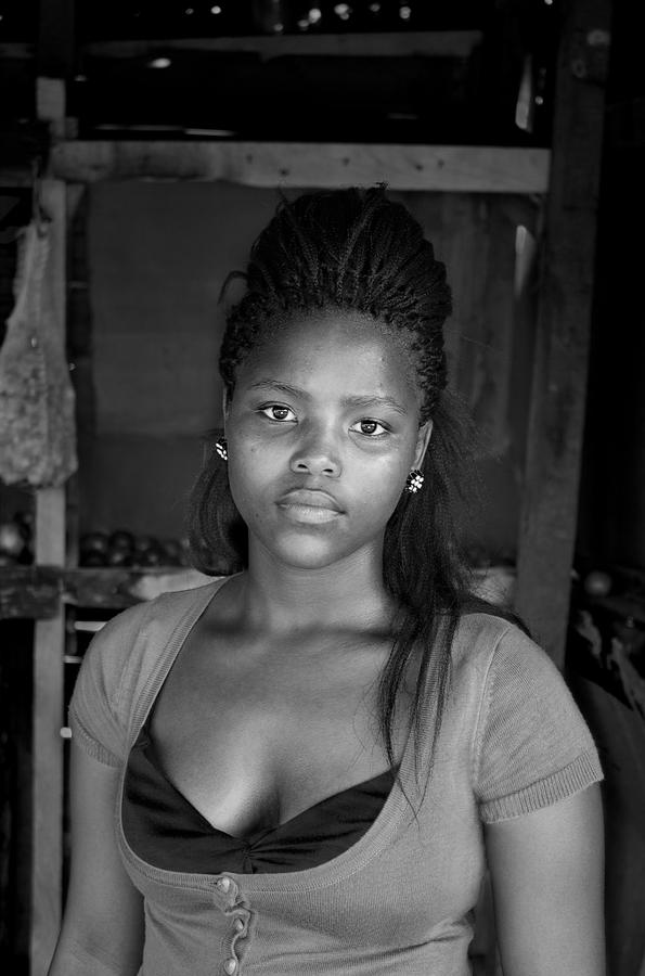 A woman wearing a tshirt and large earrings, her hair pulled back