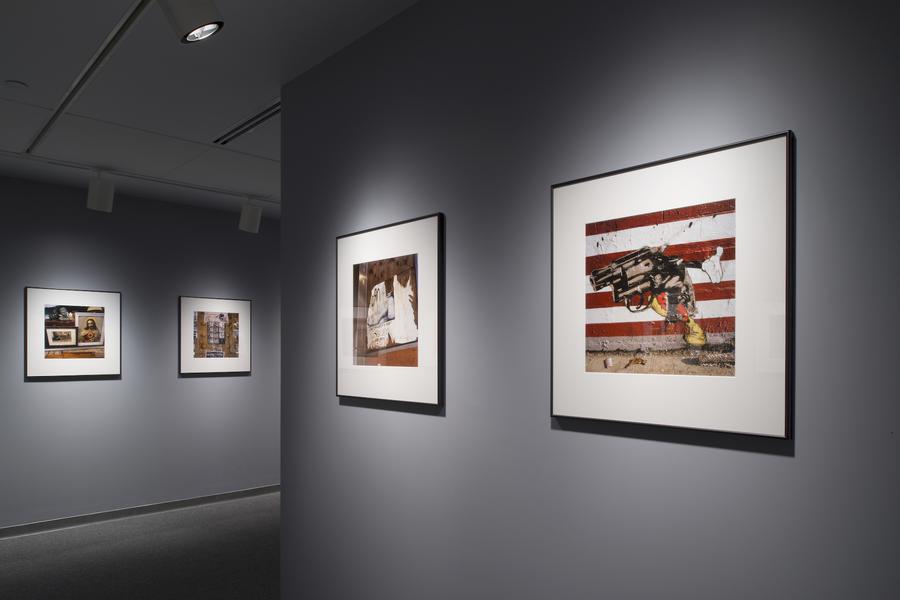 Square photographs framed with a wide white mat on a grey wall