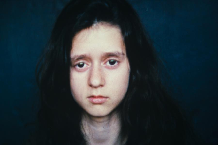 A young girl with dark hair pouting