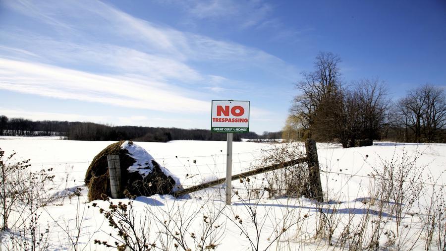 A snowy field, a sign reads "No trespassing" in bright red