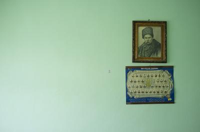 Two small framed photographs on an empty green wall